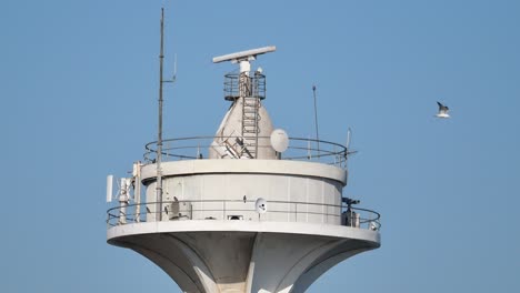 Top of a white observation tower with communication equipment