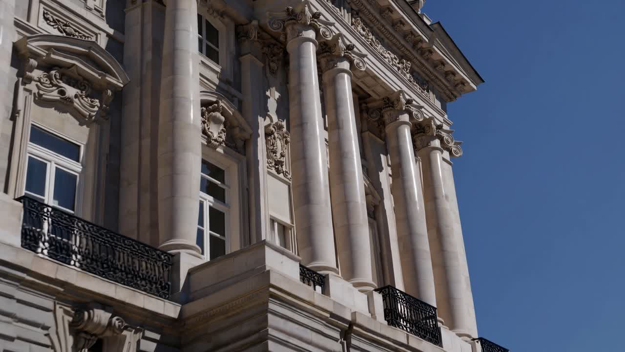 Ripresa video grandangolare di un grandioso edificio neoclassico con una bandiera spagnola, che inquadra i turisti.