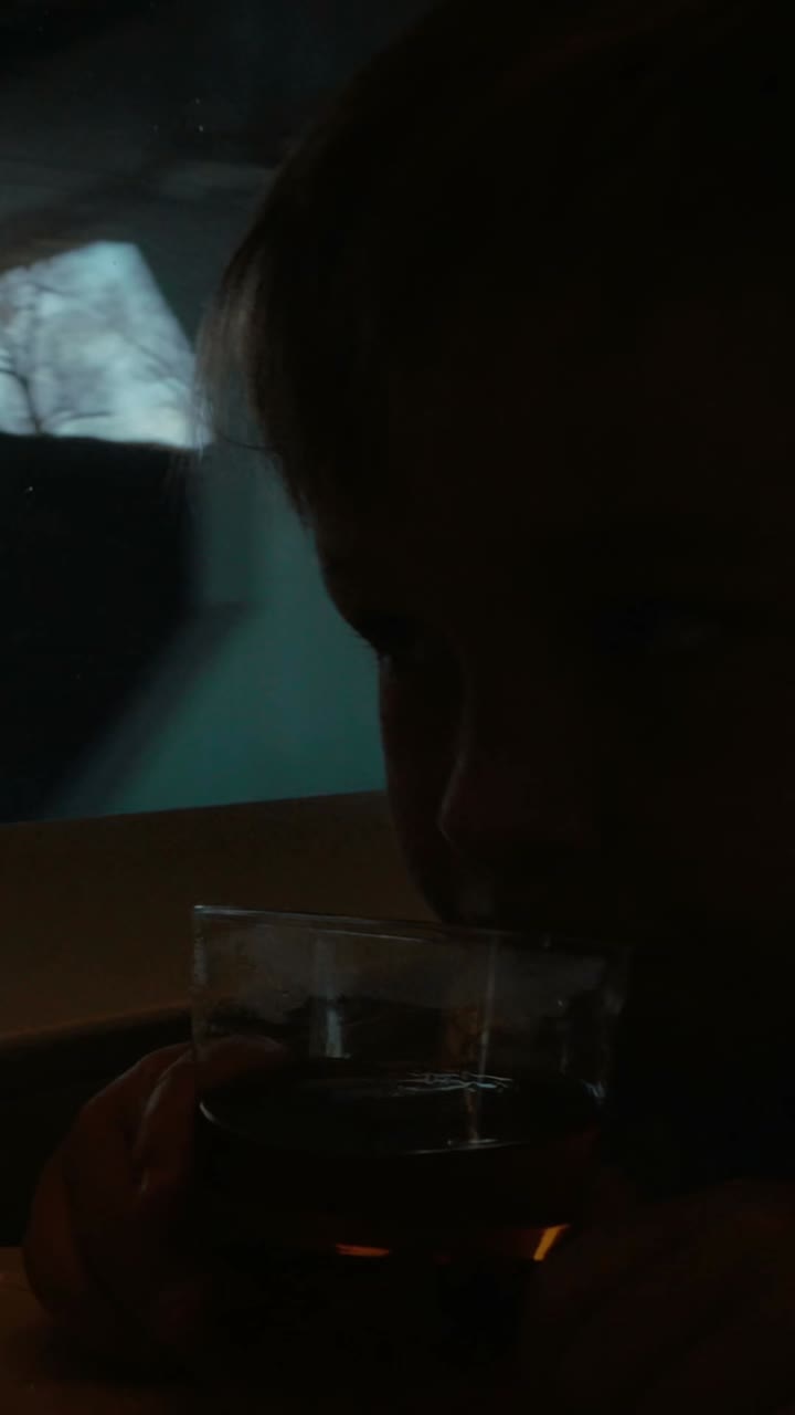 Child drinking juice by a train window