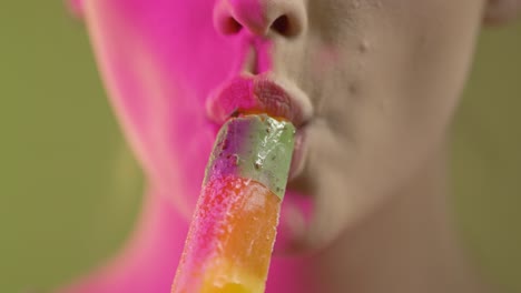 close-up of woman's face and mouth, eating fruits flavor popsicle ice cream, colorful studio shot