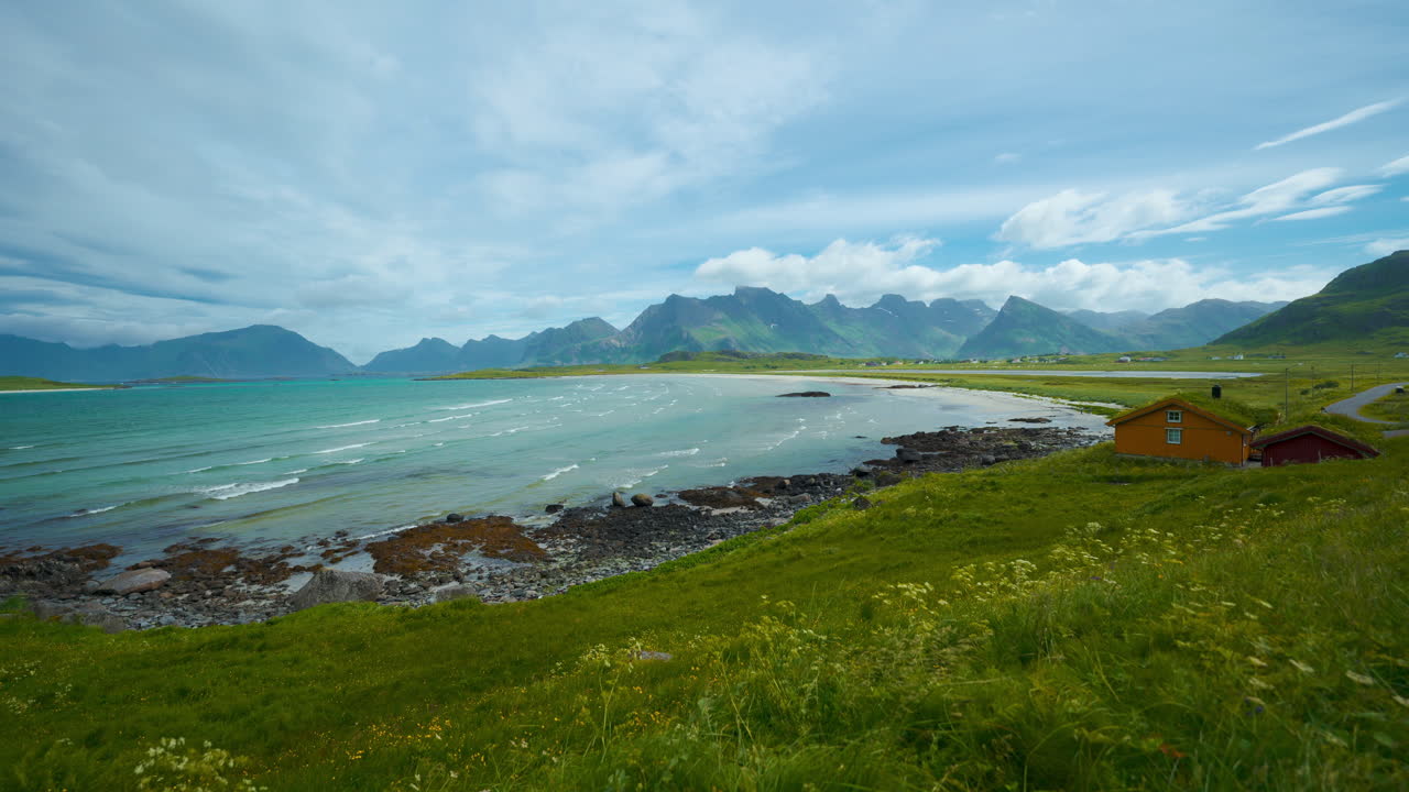 Scenic Lofoten island sandy beach cinemagraph, Norway, Scandinavia. Historic wooden houses. Seaside ocean bay