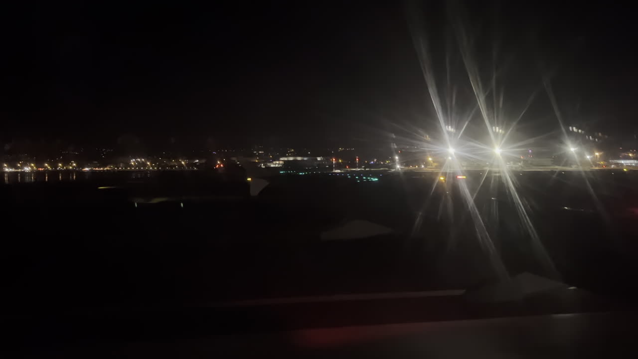 View from an airplane window of the aircraft taking off at night