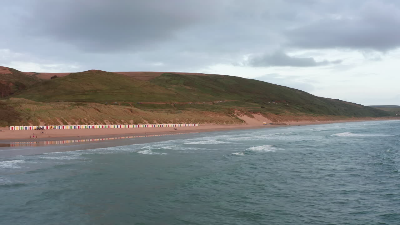 revelación aérea de una playa de arena - surfistas al atardecer durante el verano