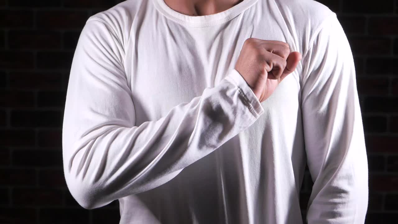 색 장갑 셔츠 를 입은 남자 가 주먹 을 보여 준다