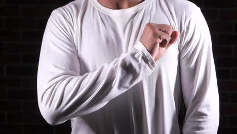 hombre con camisa blanca de manga larga mostrando el puño