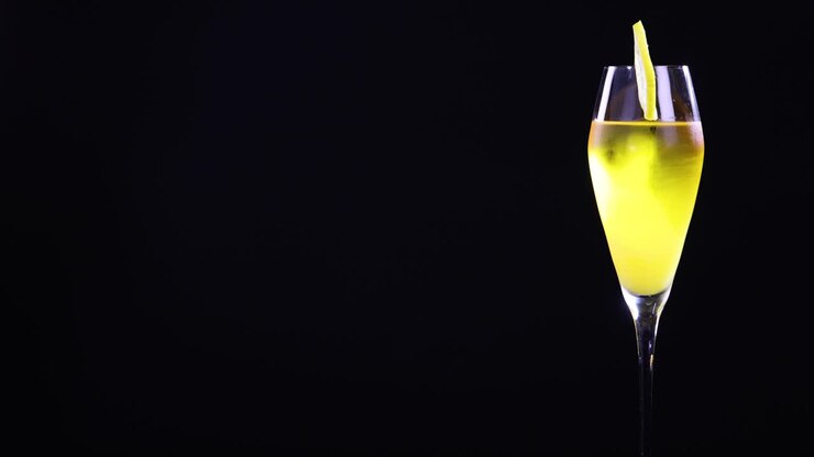 A lemon sour cocktail in a glass with a lemon slice garnish, set against a black background with bright lighting