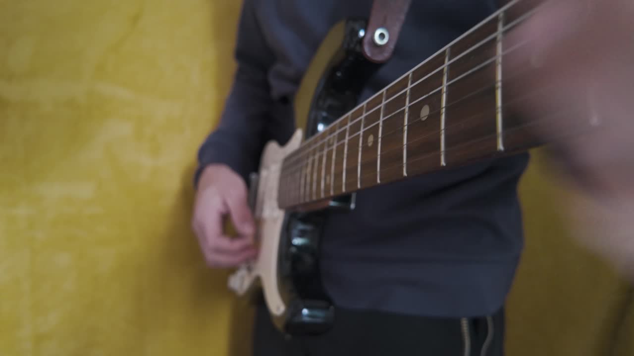A person passionately playing an electric guitar, showcasing smooth strumming and energetic performance, sliding up and down