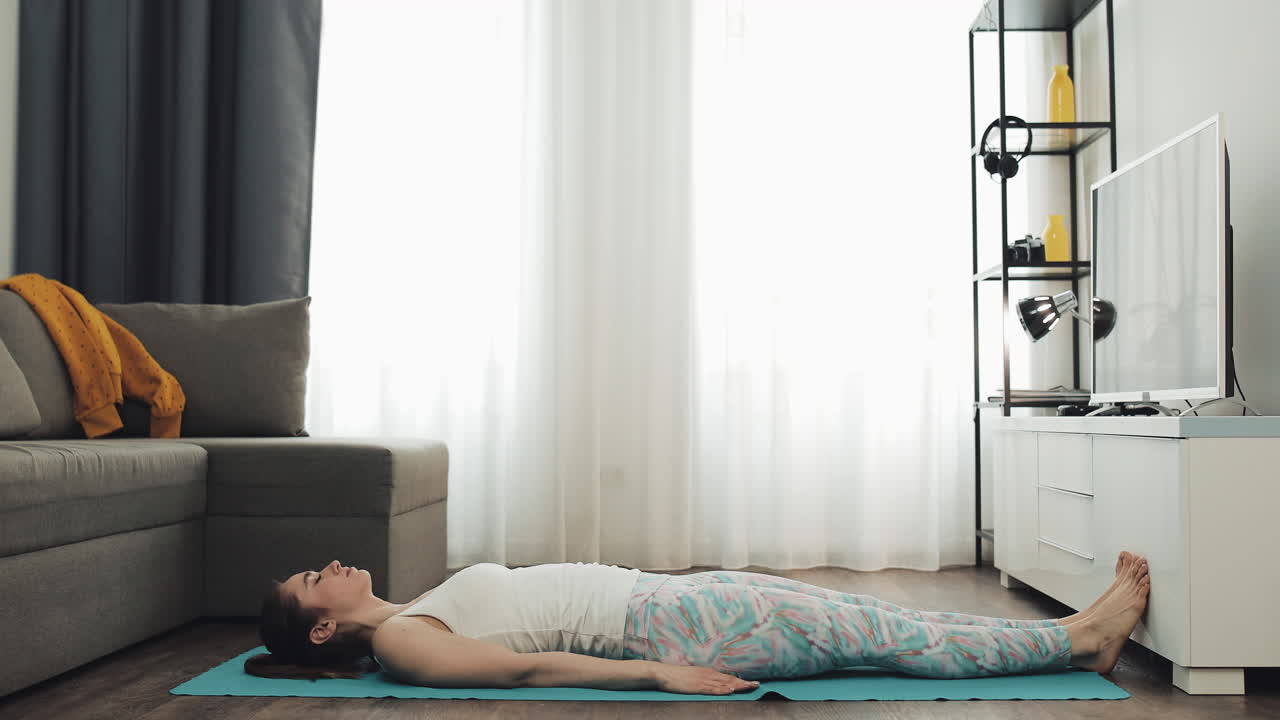mujer haciendo ejercicios de yoga en casa
