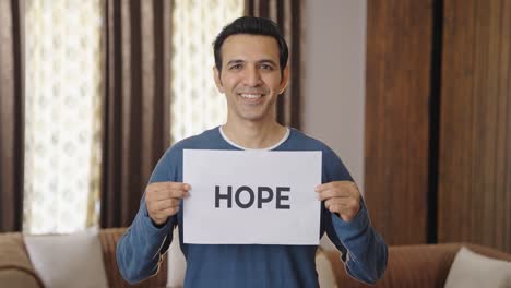 happy indian man holding hope banner