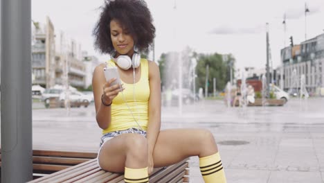 Sporty-girl-using-smartphone-on-bench