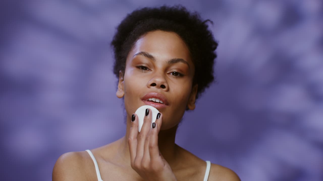 mujer quitando el maquillaje con una almohadilla de algodón