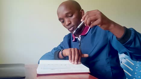 young-Black-Africa-man-reading-in-the-house-during-Ukraine-Russia-war