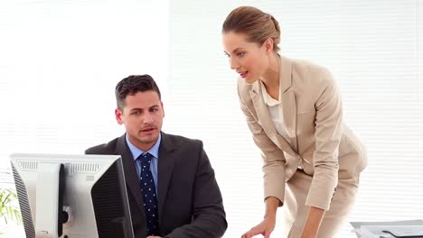 businessman showing someting to colleague at desk