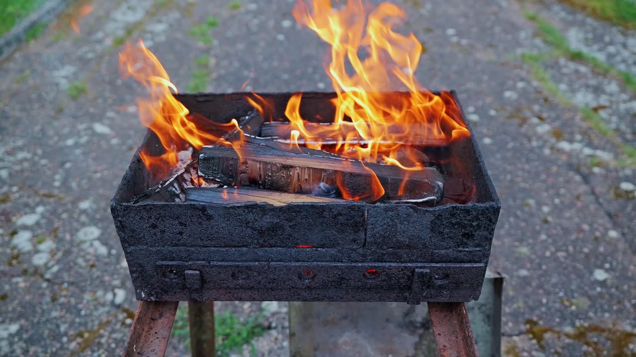 Slow motion fire scene reveals dancing flames, glowing embers in rustic setting