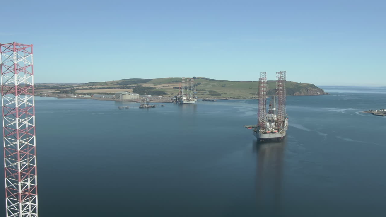 An aerial view of three oil rigs on the Cromarty Firth on a sunny summer's day. Flying towards the rigs.