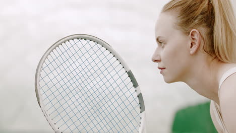 CU-Portrait-of-focused-young-Caucasian-female-tennis-player-preparing-for-a-serve.-120-FPS-slow-motion,-4K-UHD-RAW-graded-footage