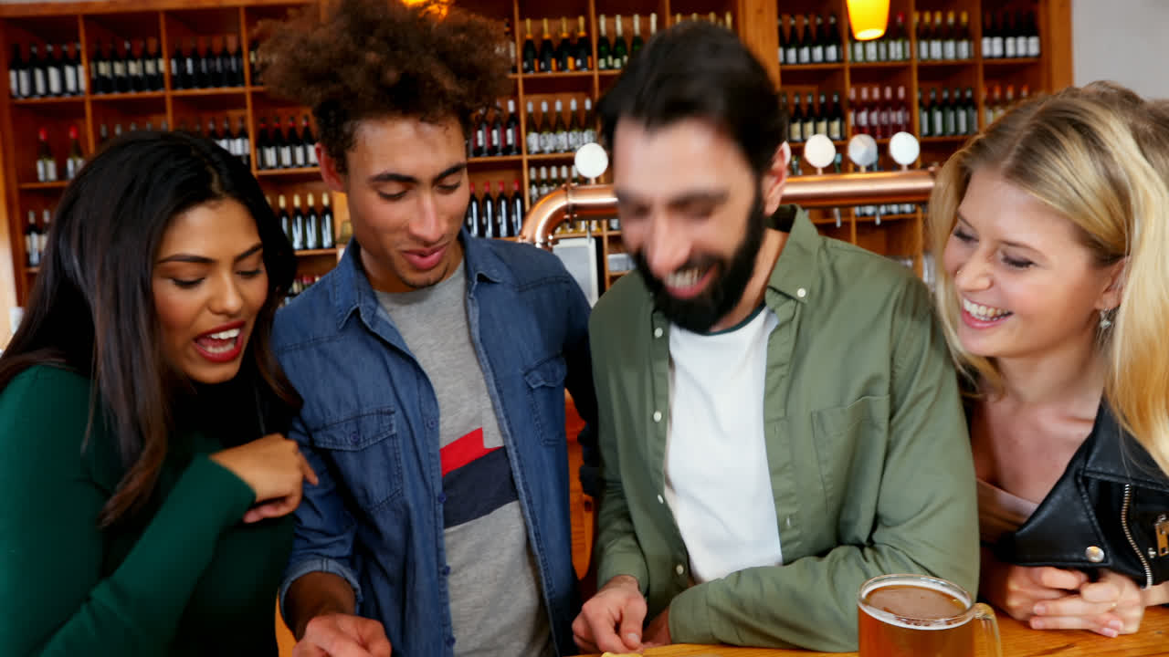 amigos tomando un vaso de cerveza y comida mexicana en el bar 4k