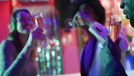 video of a diverse group of happy friends making a toast with glasses of champagne at a nightclub