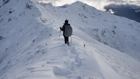 Una-Mujer-Caminante-Cruza-Una-Cresta-Nevada-A-Gran-Altura-En-La-Pista-Kepler-En-Nueva-Zelanda,-Fiordland