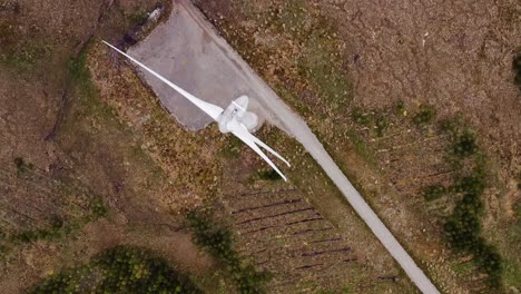 birds eye view drone shot of a track road near a wind farm on the hebrides