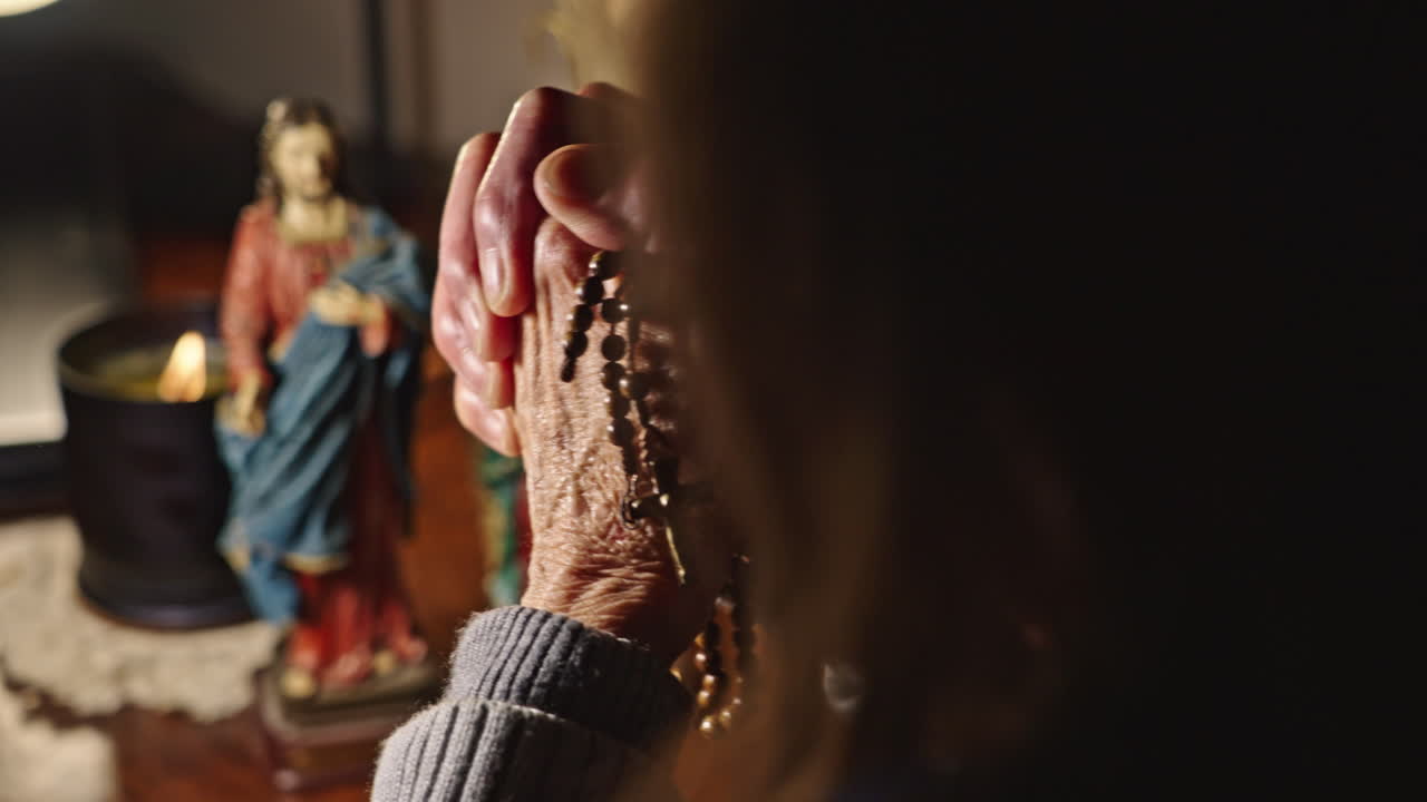 Close-up of Elderly Woman's Hands Praying with Rosary