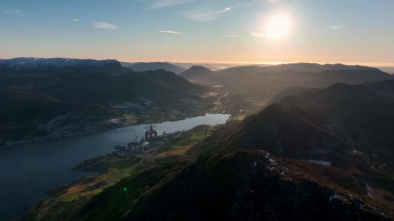 Forward aerial over mountains in Vindafjord and Olen at sunset with fjord and misty valleys below