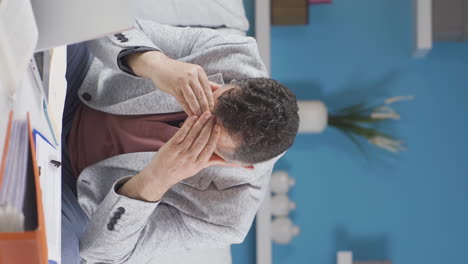 Vertical-video-of-Home-office-worker-old-man-getting-depressed.