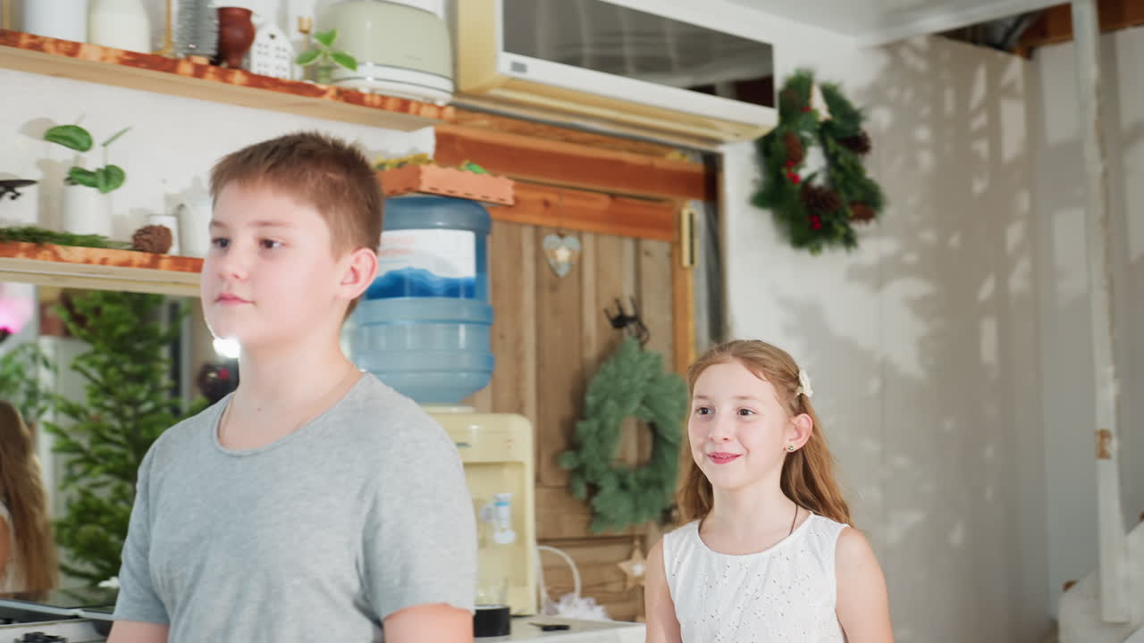 boy in gray top walking toward his mother with sister in white gown, both ready to give her a warm hug, cozy home environment with festive decorations, happy family moment, close sibling bond