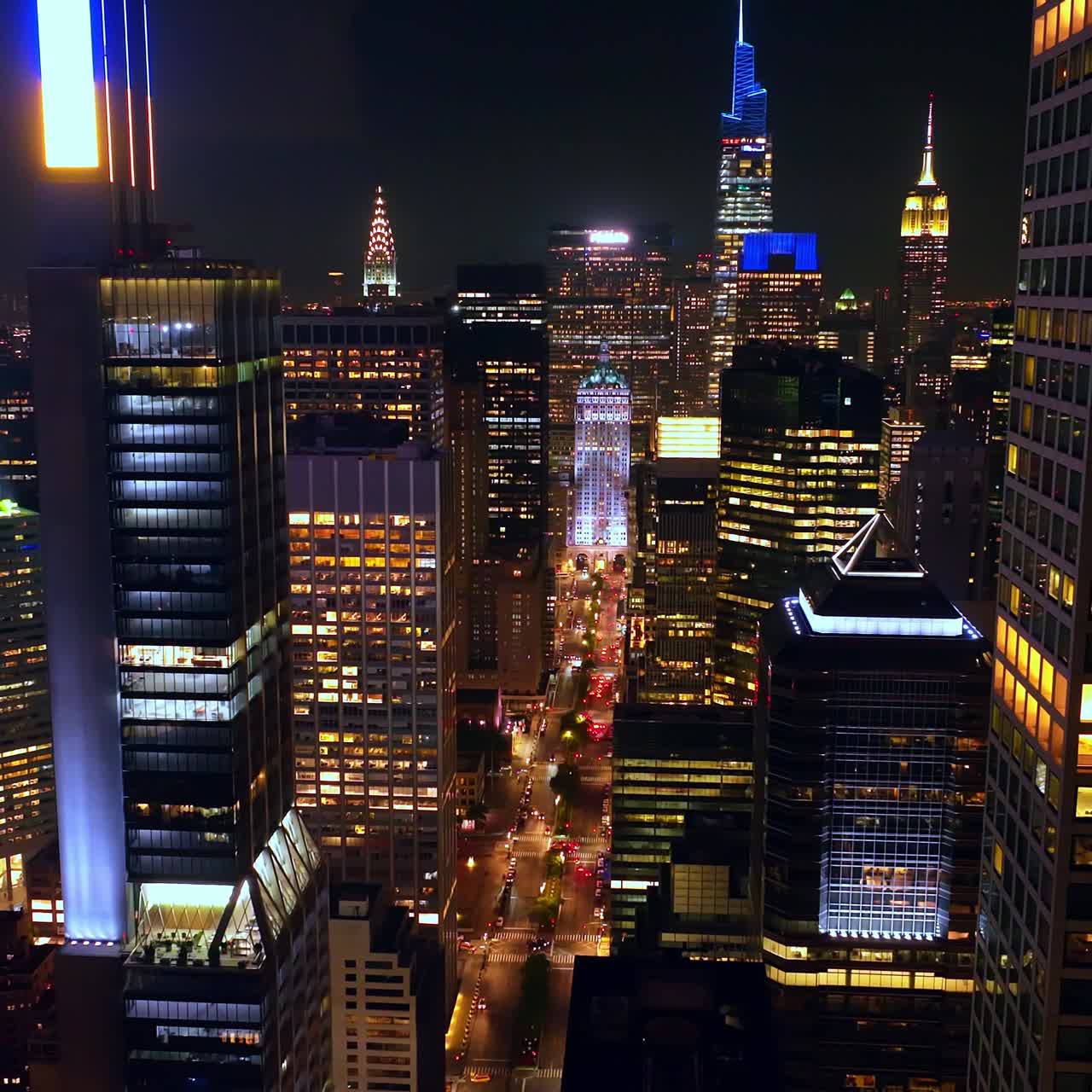 Light broad street among the sparkling skyscrapers. Fantastic New York panorama at night time