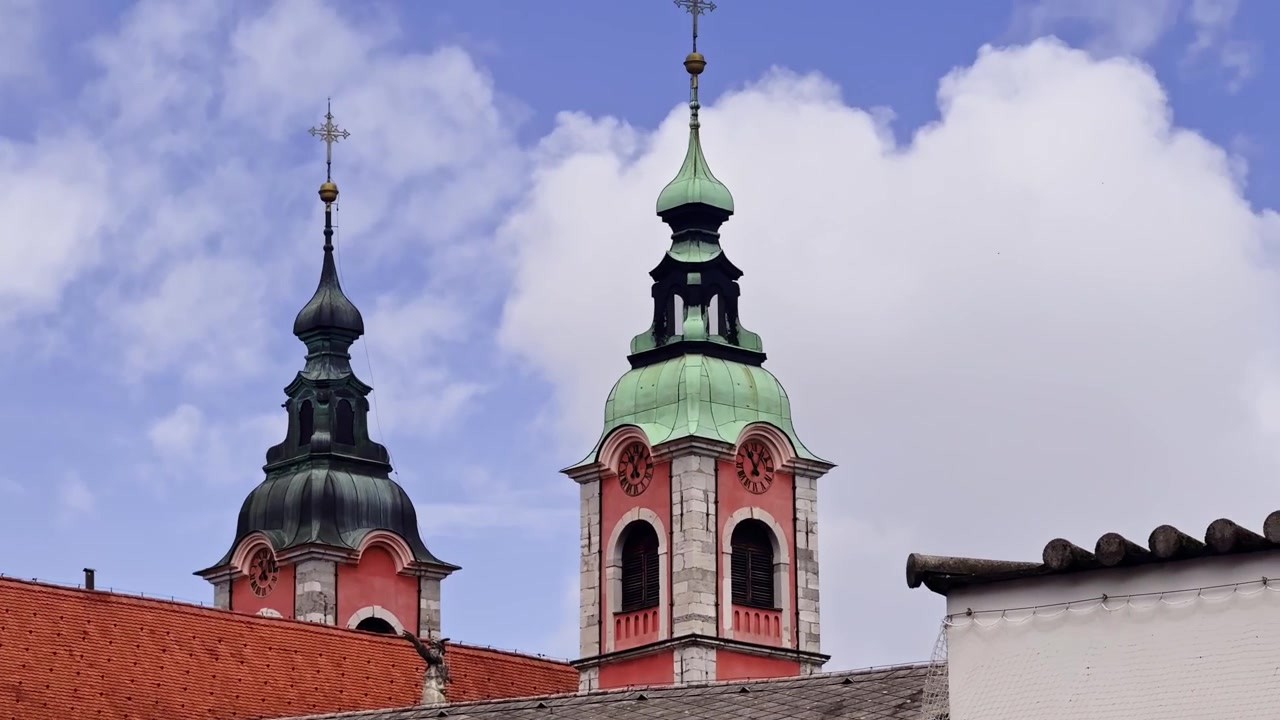 Tetti e campanili gemelli della Cattedrale di Lubiana in Slovenia, che mostrano tetti in tegole rosse, cupole verdi, dettagli di chiese barocche e architettura storica del centro storico