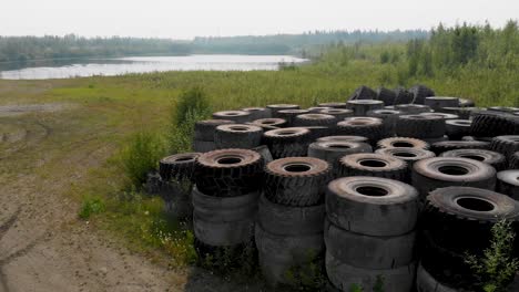 4k drone video of discarded giant excavator tire pile in wilderness near fairbanks, ak during summer day-2