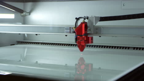 un cortador láser en funcionamiento en un laboratorio de impresión 3d, filmado en r3d