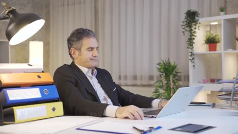 Stressed-waiting-mature-businessman-looking-at-laptop-at-table.