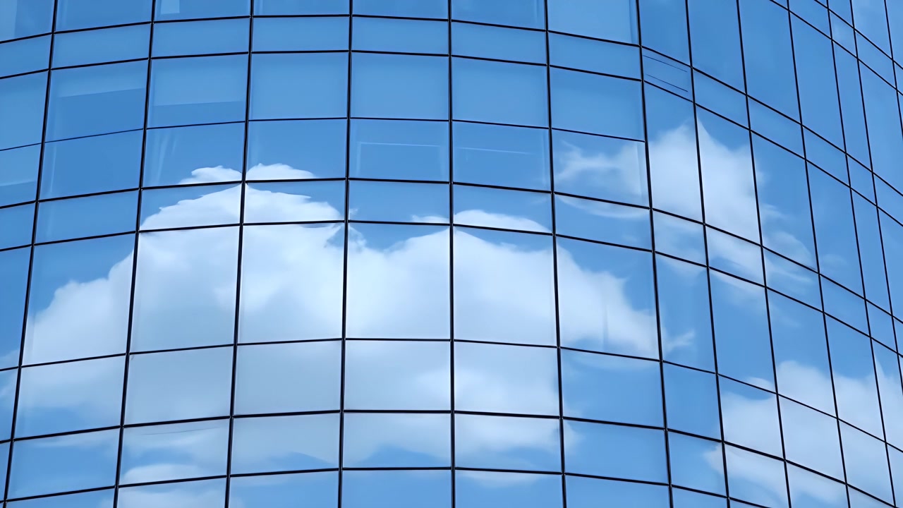 Nuvens refletindo na fachada de um arranha-céu moderno de vidro