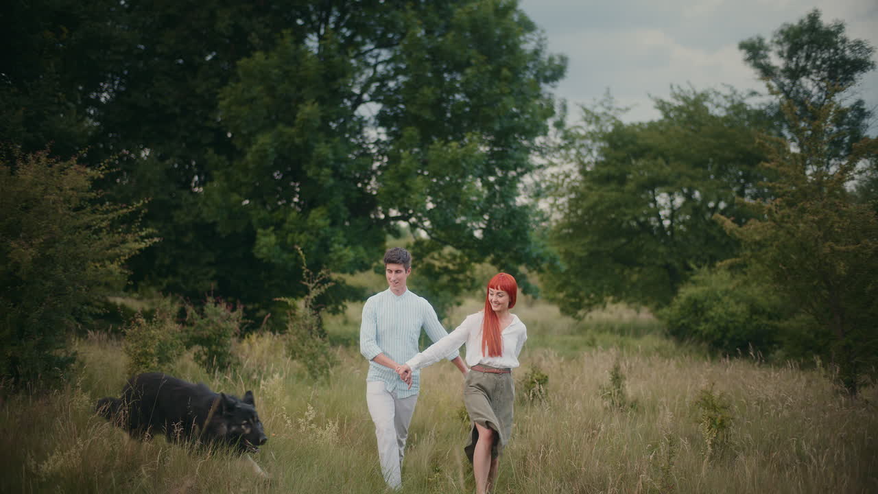 Couple Walking with Dog in Field