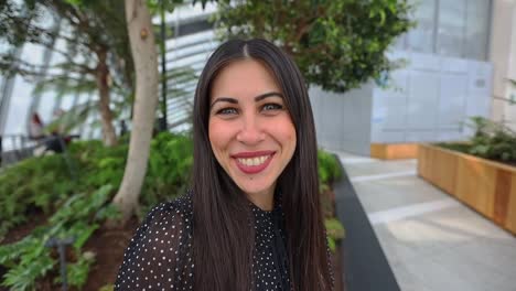 Joven-Hispana-Con-El-Pelo-Largo-Y-Oscuro-Sonriendo-Mirando-A-La-Cámara-En-El-Moderno-Jardín-Interior