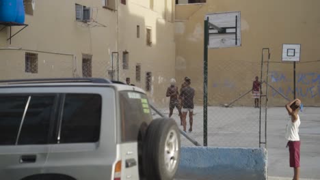 children playing soccer in a cuban street court