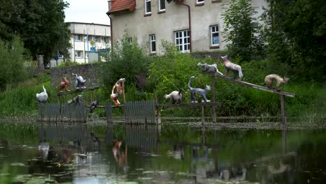 artistic sculpture of cats placed over the river on the fence