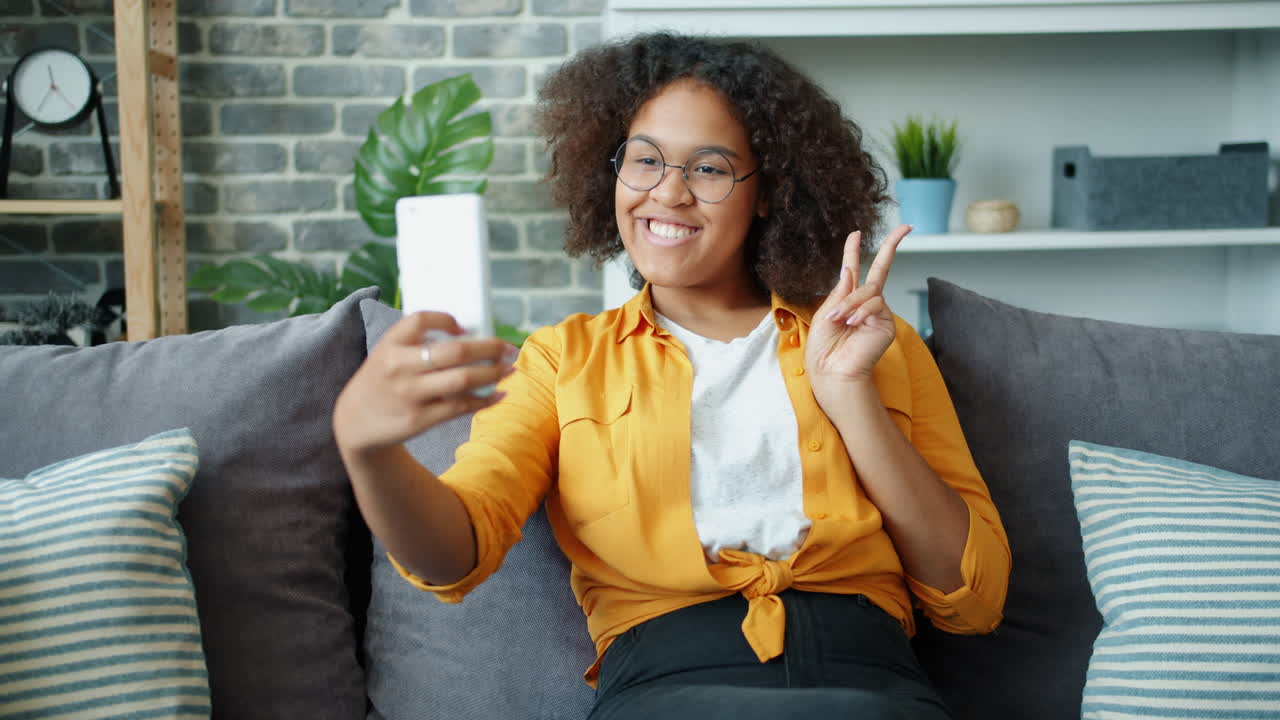 Young woman taking a selfie on a couch