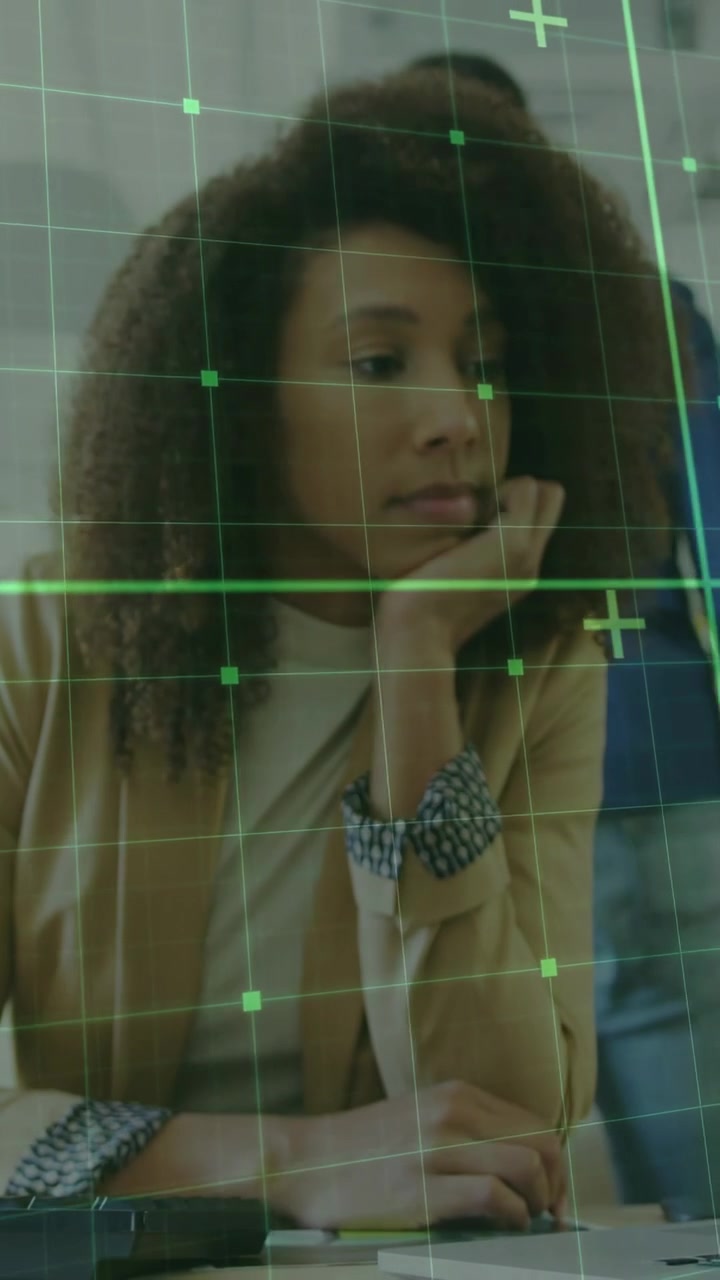 Vertical video: Office pro leaning moving hand starting green grid scanning face+hands showing data
