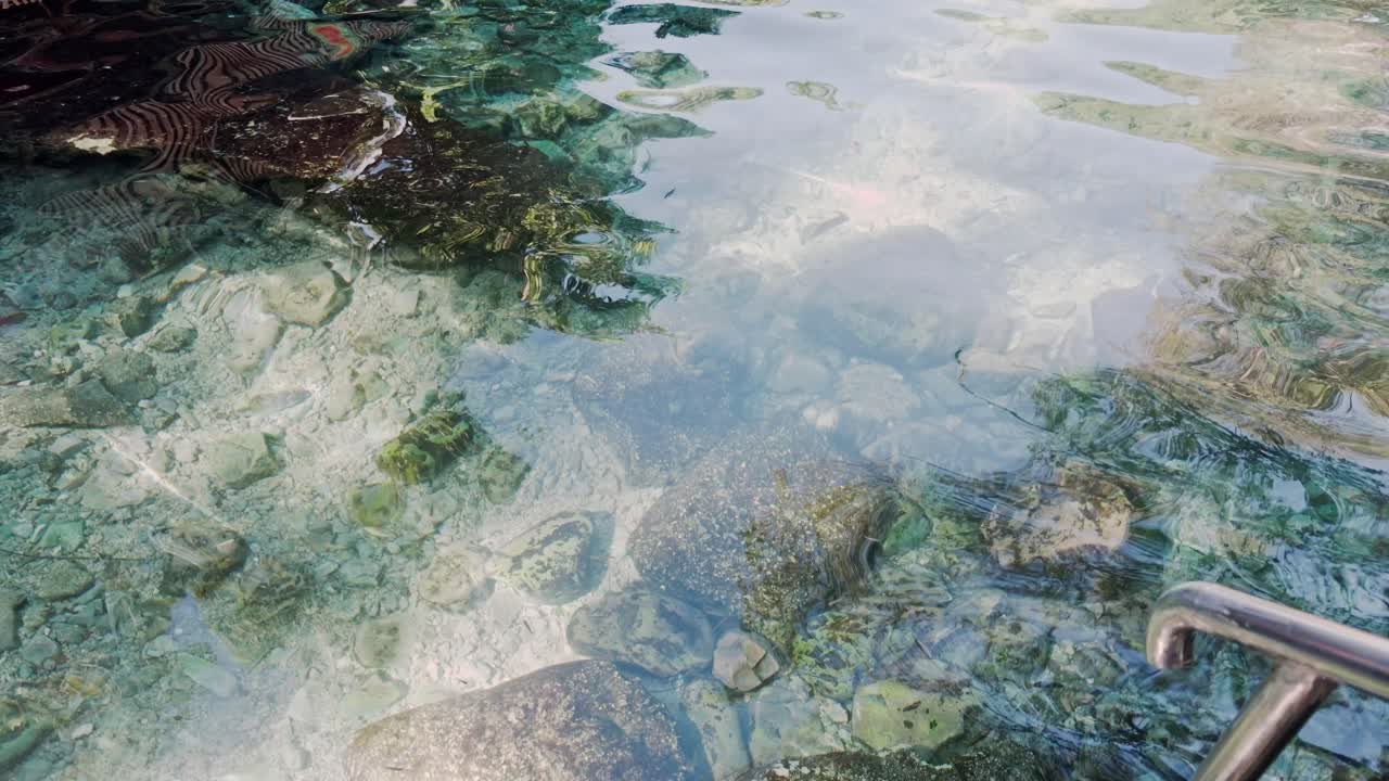 Primo piano POV dell'acqua cristallina della piscina naturale Las Marias nella Repubblica Dominicana