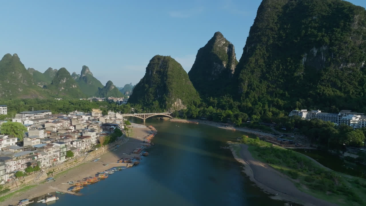 Drone rising over Li river, toward the Yangshuo bridge, summer sunset in China
