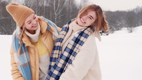 two happy women having fun in the snow