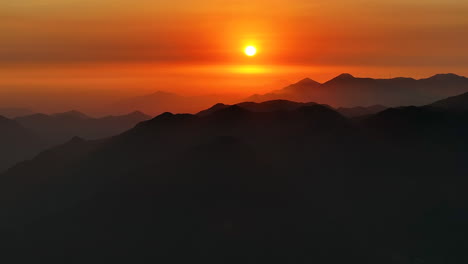 Links-Luftaufnahme-Drohne-Schwenken-Orange-Sonnenuntergang-Goldene-Stunde-Ausgeschnitten-Berge-Dunst-Wolke-Kontrastiert-Lima-Peru