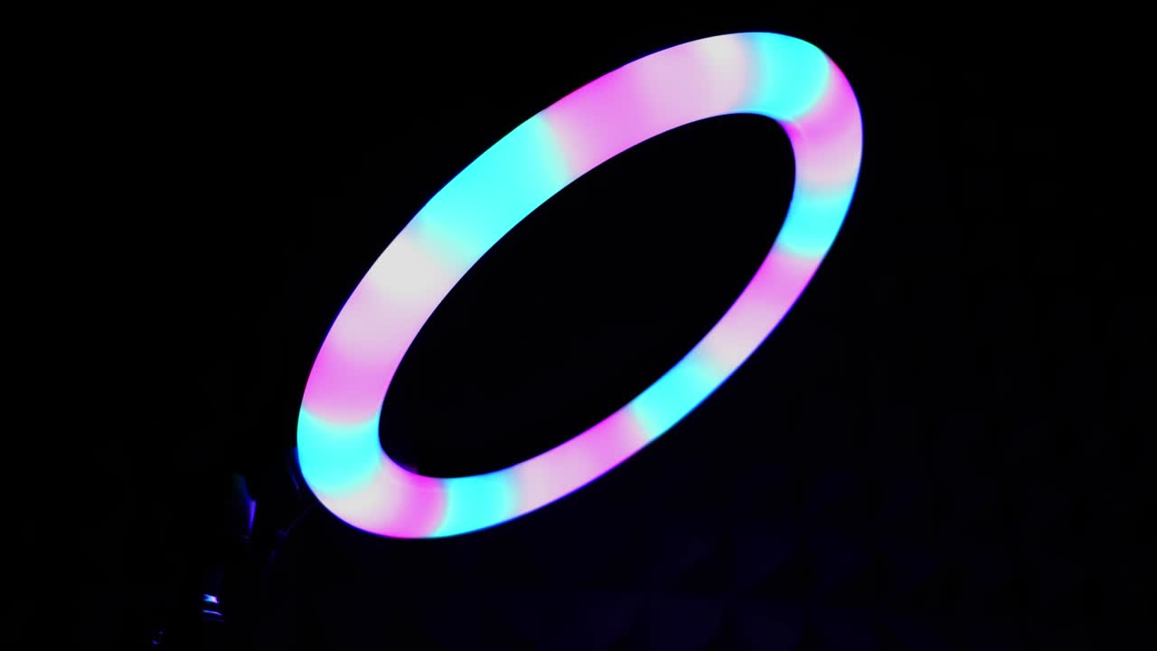 Luminous ring rgb lamp. Multicolored light in a dark room, close-up.