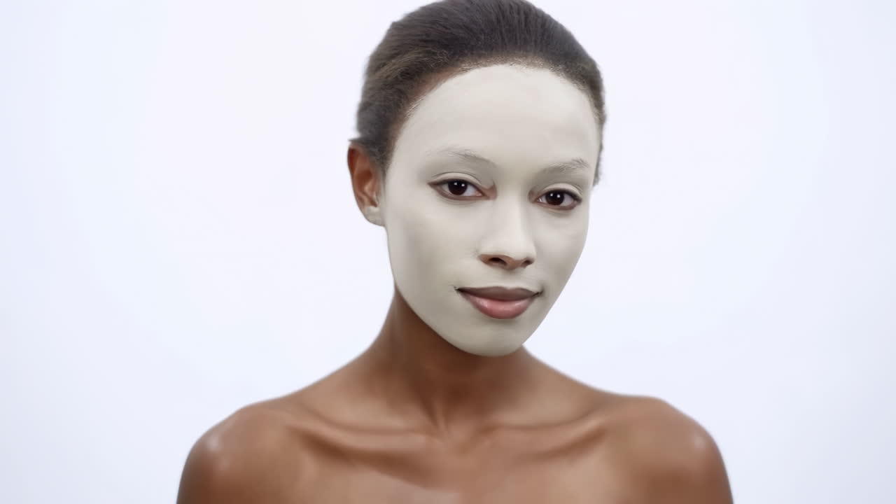 Junge Frau mit Gesichtsmaske öffnet die Augen im Studio