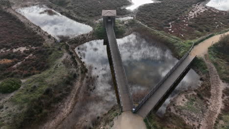 estartit nature reserve wooden bridges and bird watching platform boardwalk over marsh pools aerial view