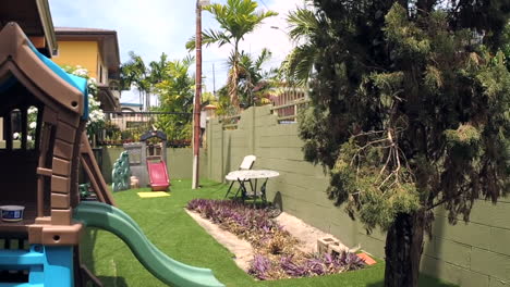 patio trasero suburbano con casa de juegos para niños en un día ventoso