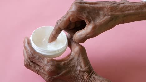 persona de edad avanzada aplicando crema a sus manos