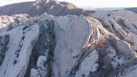 Shadow-and-sunny-hillsides-of-the-Devils-Punchbowl,-drone-flight-over-mountains-and-slopes-and-the-nature-in-between,-slowmotion-forward